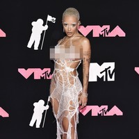 Doja Cat dengan gaya eksentriknya memakai gaun seperti sarang laba-laba yang sudah rusak. Foto: Evan Agostini/Invision/AP
