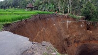 Wisatawan memutar balik kendaraannya usai melihat kondisi jalan yang ambles di lingkungan Cebok, Desa Kedisan, Tegallalang, Gianyar, Bali, Rabu (13/9/2023).  