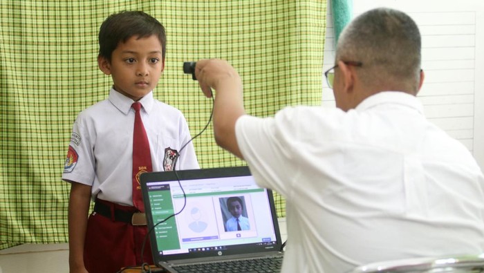 Jemput bola pembuatan KIA di sekolah Petugas Dinas Kependudukan dan Pencatatan Sipil melakukan perekaman data Kartu Identitas Anak (KIA) di Sekolah Dasar Al-Falah, Kota Kediri, Jawa Timur, Rabu (13/9/2023). Layanan dengan metode jemput bola pembuatan KIA ke sejumlah sekolah tersebut agar anak-anak berusia di bawah 17 tahun yang belum menikah memiliki KIA. ANTARA FOTO/Prasetia Fauzani/nym.