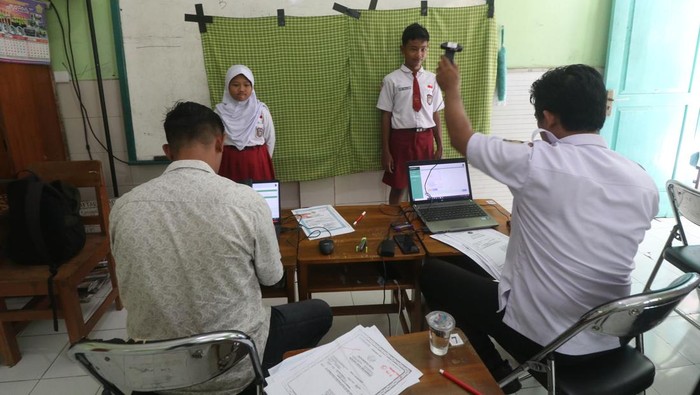 Jemput bola pembuatan KIA di sekolah Petugas Dinas Kependudukan dan Pencatatan Sipil melakukan perekaman data Kartu Identitas Anak (KIA) di Sekolah Dasar Al-Falah, Kota Kediri, Jawa Timur, Rabu (13/9/2023). Layanan dengan metode jemput bola pembuatan KIA ke sejumlah sekolah tersebut agar anak-anak berusia di bawah 17 tahun yang belum menikah memiliki KIA. ANTARA FOTO/Prasetia Fauzani/nym.