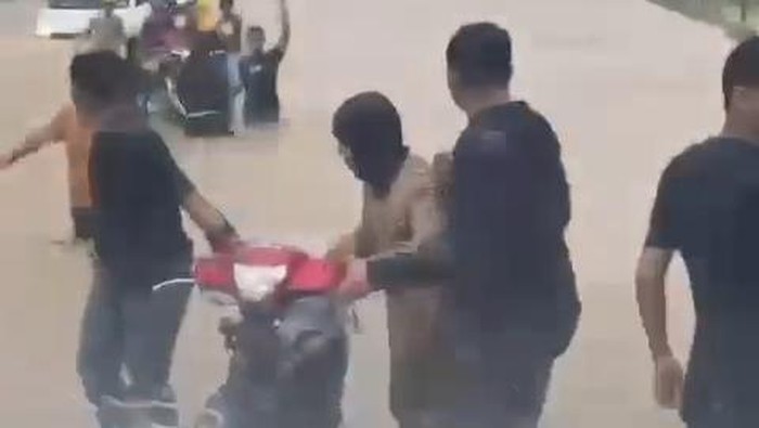 Karyawan PT IWIP berupaya menyelamatkan kendaraan roda dua milik mereka dari terjangan banjir.