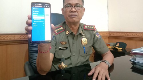 Kasatpol PP Kota Denpasar, Anak Agung Ngurah Bawa Nendra ketika menunjukkan tampilan dari media aduan berbasis WhatsApp Bot pada Rabu (13/9/2023).