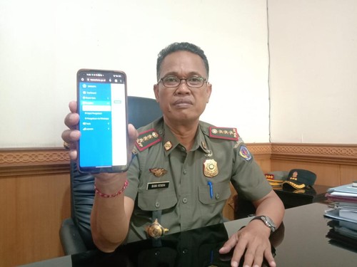 Kasatpol PP Kota Denpasar, Anak Agung Ngurah Bawa Nendra ketika menunjukkan tampilan dari media aduan berbasis WhatsApp Bot pada Rabu (13/9/2023).