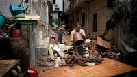Kini warga mulai membersihkan sisa-sisa lumpur dan sampah di rumahnya yang terbawa akibat banjir.  