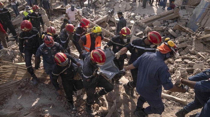 Maroko Porak-poranda Diguncang Gempa, Korban Tewas Hampir 3.000 Jiwa A rescue team recovers the body of a woman who was killed by the earthquake, in the town of Imi N'tala, outside Marrakech, Morocco, Tuesday, Sept. 12, 2023. (AP Photo/Mosa'ab Elshamy)