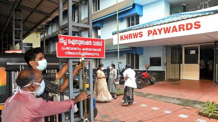 Staff members install a sign reading 