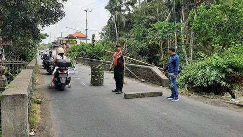 Anggota Polsek Ubud menutup sebagian jalan Denpasar-Ubud di Desa Singakerta, Gianyar. Kendaraan dari Denpasar menuju Ubud dilarang melalui jalan itu mulai Rabu (13/9/2023).