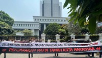 Massa membentangkan spanduk dan poster. Aksi ini berjalan damai. 