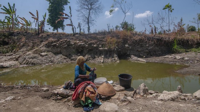 Warga membawa kendi berisi air yang diambil dari lubang di dasar sungai, Dukuh Kalitlawah, Ngaren, Juwangi, Boyolali, Jawa Tengah, Rabu (13/9/2023). Warga setempat memanfaatkan sisa air pada dasar sungai saat musim kemarau untuk digunakan mencuci dan mandi, sedangkan untuk kebutuhan minum dan memasak warga menggunakan sisa air sumur, membeli air atau dengan bantuan distribusi air bersih. ANTARA FOTO/Aloysius Jarot Nugroho/rwa.