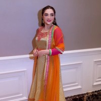 Ashanty tampil dengan busana cerah memadukan gaun warna emas-pink serta outer oranye. Tak lupa sepasang anting hoop melengkapi gayanya. Foto: Instagram