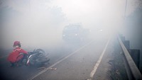 Asap dari kebakaran lahan itu juga menyebabkan kecelakaan. Tampak seorang petugas sedang menolong pengendara roda dua yang mengalami kecelakaan akibat menembus asap di Jalan Lintas Palembang-Indralaya.  