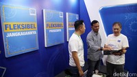 Corporate Business Head BFI Finance Stanly Darisang didampingi Heto Strategy Head BFI Finance Erick berbincang dengan nasabah di booth BFI Finance. 