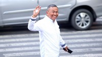 Dahlan melempar senyuman sambil melambaikan tangan saat tiba di gedung KPK, Jakarta.  