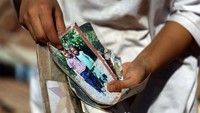 Imane Ait Said menunjukan foto anggota keluarganya yang menjadi korban gempa Maroko.  