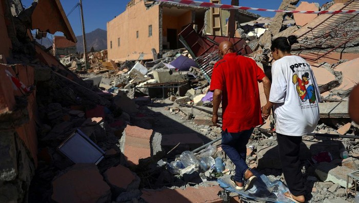 Ibrahim Ait Said, father of 19-year-old Imane and who have lost 10 relatives in the quake, looks through belongings at the site of their damaged house, in the aftermath of a deadly earthquake, in Talat N'Yaaqoub, Morocco September 13, 2023. REUTERS/Hannah McKay