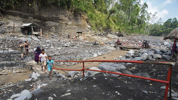 Jalur alternatif Malang-Lumajang swadaya masyarakat Sejumlah warga melintasi jembatan bambu perlintasan Sungai Kali Glidik di Malang, Jawa Timur, Kamis (14/9/2023). Jalur alternatif Malang-Lumajang yang dibuat secara swadaya tersebut digunakan masyarakat yang hendak melintaskarena jembatan Kali Glidik putus akibat diterjang lahar hujan Semeru. ANTARA FOTO/Irfan Sumanjaya/tom.