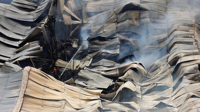 Kebakaran Besar Hancurkan Pasar di Dhaka Bangladesh Firefighters and people work to douse a fire that broke out at the Mohammadpur Krishi Market in, Dhaka, Bangladesh September 14, 2023, in this screengrab taken from a social media video.