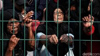 Sejumlah warga mengantre sambil memantau proses penyaluran dari balik pagar RPTRA.  