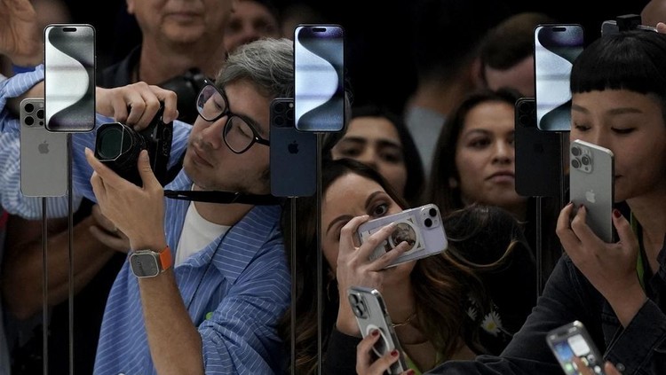 People take photos of the iPhone 15 Pro phones during an announcement of new products on the Apple campus in Cupertino, Calif., Tuesday, Sept. 12, 2023. (AP Photo/Jeff Chiu)