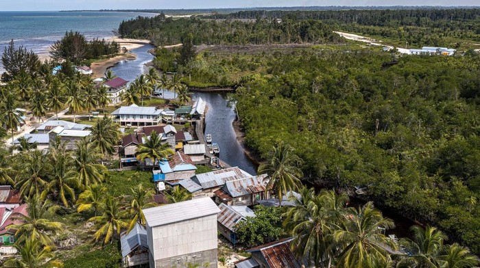Sisi Lain di Balik Pengembangan Kawasan Industri di RI Kampung Baru village lies on the edge of the construction site of the Kalimantan Industrial Park Indonesia (KIPI), right, in Mangkupadi, North Kalimantan, Indonesia Thursday, Aug. 24, 2023. The industrial park being built in Indonesia on the tropical island of Borneo that has attracted billions of dollars in foreign and domestic investment is damaging the environment in an area where endangered species live and migrate. (AP Photo/Yusuf Wahil)