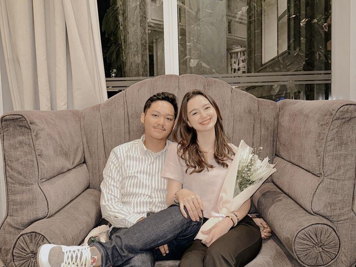 Sarah Menzel dan Azriel Hermansyah berpose saat Hari Valentine. Sarah yang memegang buket bunga terlihat tersenyum duduk di sebelah Azriel. (Foto: Instagram ssarah_menzel)