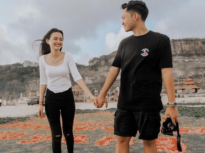 Sarah Menzel dan Azriel Hermansyah merayakan hari jadian mereka di sebuah landasan helikopter di Bali pada 2021 silam. Mereka saling tatap dan berpegangan tangan dengan latar belakang pasir berisi taburan bunga bertuliskan “Happy Anniversary Sayang”.