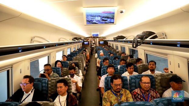 Sejumlah penumpang menunjukkan stiker penanda uji coba kereta cepat Jakarta Bandung di Halim - Tegalluar, Jumat, (15/9). (CNBC Indonesia/Muhammad Sabki)