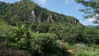 Bukit dari bebatuan karst menjulang di pinggir jalur menuju curug