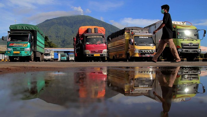 Warga melintas di depan truk untuk menyeberang pulau di Pelabuhan Ferry Bastiong, Kota Ternate, Maluku Utara, Sabtu (16/9/2023). PT ASDP Indonesia Ferry Cabang Ternate Maluku Utara untuk sementara membatasi tonase muatan truk pengangkut barang maksimal 15 ton dari Pelabuhan Bastiong ke sejumlah daerah di Maluku Utara karena dermaga di bagian selatan yang rusak ditabrak KMP Mutiara Pertiwi pada Mei lalu masih dalam perbaikan. ANTARA FOTO/Andri Saputra/foc.