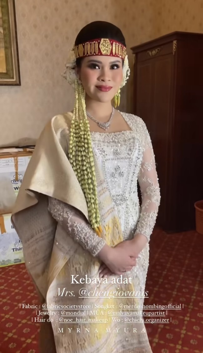 Chen Giovani mempercayakan rancangan baju pernikahannya kepada desainer Myrna Myura. Selama resepsi, dia melengkapi penampilannya dengan songket dan sortali alias ikat kepala berwarna merah yang sakral.Foto: Instagram Myrna Myura