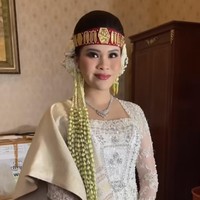 Chen Giovani mempercayakan rancangan baju pernikahannya kepada desainer Myrna Myura. Selama resepsi, dia melengkapi penampilannya dengan songket dan sortali alias ikat kepala berwarna merah yang sakral.Foto: Instagram Myrna Myura