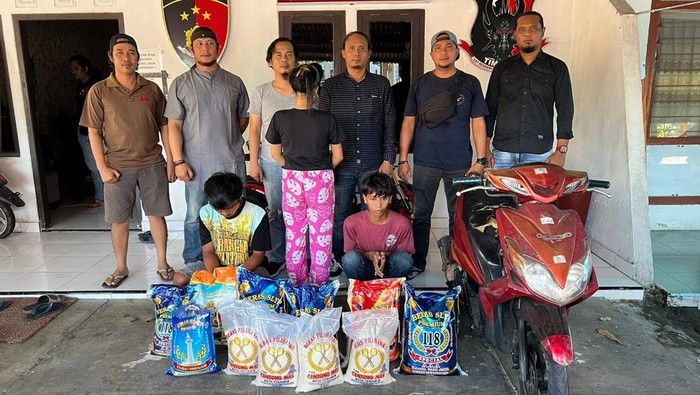 Pelaku (tengah wanita) dan dua rekannya usai ditangkap polisi bersama barang bukti beras.