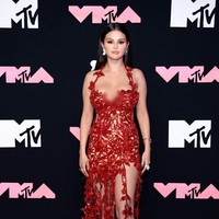 Dress itu semakin mempertegas keseksian Selena Gomez dengan detail high slit atau belahan tinggi di paha. Selena memadukan dress tersebut dengan heels dan anting serba merah sesuai dengan busananya. Foto: Dok Getty Images via AFP