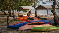 Seorang pengelola persewaan fasilitas wisata menyusun perahu kano di kawasan pariwisata Pantai Melayu, Pulau Rempang, Batam, Kepulauan Riau, Sabtu (16/9/2023). 