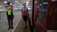 Petugas Passenger Service Kereta Api Cepat Jakarta Bandung menyambut penumpang yang akan menaiki kereta. 