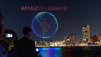 Cahaya dari konfigurasi drone membentuk tampilan tiga dimensi bertuliskan Amazon Burns di atas East River, dekat Markas Besar Perserikatan Bangsa-bangsa (PBB) di New York, Amerika Serikat, Jumat (15/9/2023) malam waktu setempat atau Sabtu (16/9) WIB.  