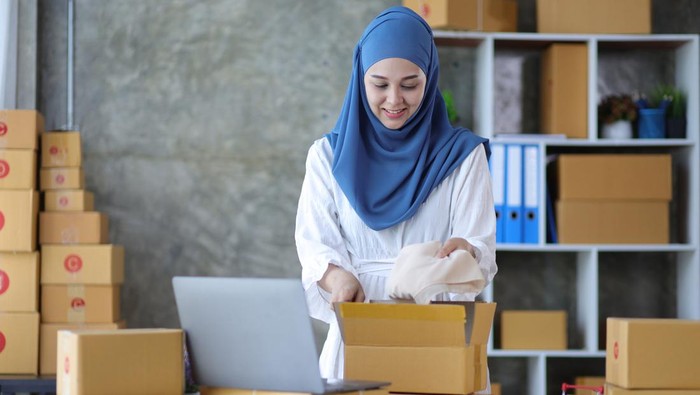 Woman online store small business owner seller entrepreneur packing package post shipping box preparing delivery parcel on table. Ecommerce drop shipping shipment service concept.