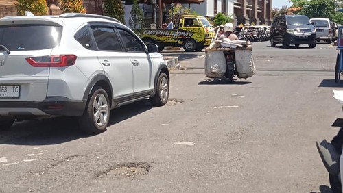 Jalan Raya Sukawati, Gianyar, Bali, berlubang, Senin (18/9/2023). Buruknya kondisi jalan tersebut dikeluhkan oleh warga setempat.