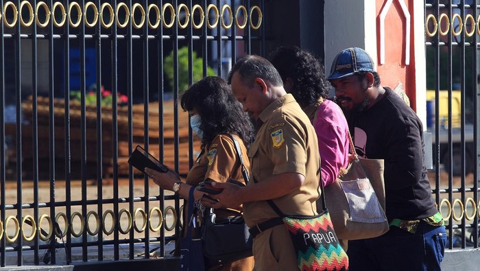 Pegawai melintasi Kantor Gubernur Provinsi Papua yang disegel warga Suku Kayo Pulau di Kota Jayapura, Papua, Senin (18/9/2023). Penyegelan yang mengakibatkan aktivitas di Kantor Gubernur Papua terganggu tersebut dilakukan untuk meminta ganti rugi atas tanah yang menjadi hak milik ulayat Suku Kayo Pulau.