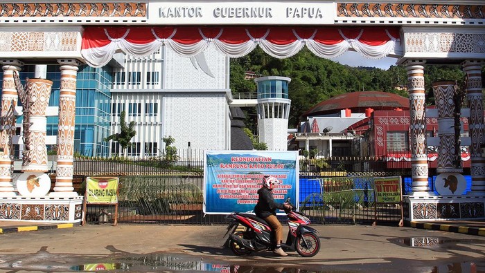 Kantor Gubernur Papua Disegel, Kenapa? Pegawai melintasi Kantor Gubernur Provinsi Papua yang disegel warga Suku Kayo Pulau di Kota Jayapura, Papua, Senin (18/9/2023). Penyegelan yang mengakibatkan aktivitas di Kantor Gubernur Papua terganggu tersebut dilakukan untuk meminta ganti rugi atas tanah yang menjadi hak milik ulayat Suku Kayo Pulau.