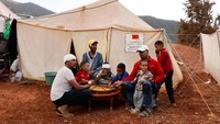 Sejumlah pengungsi berbagi santap makan di tenda darurat. REUTERS/Ammar Awad  