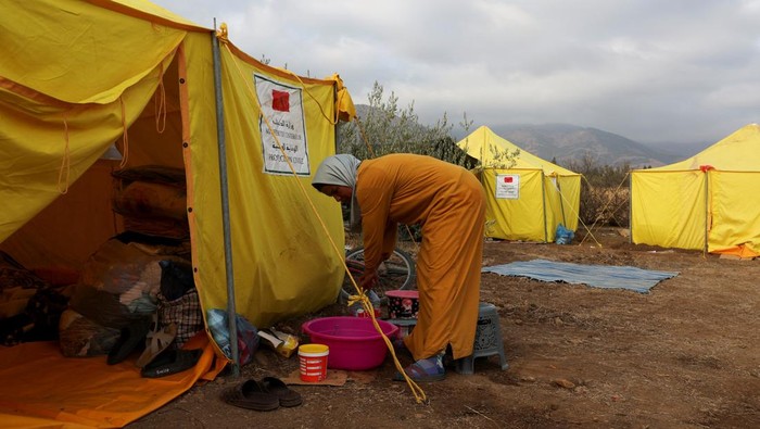 Nezha lmouden, 41, holds a bottle near humanitarian tents, in the aftermath of a deadly earthquake, in Amizmiz, Morocco September 15, 2023. REUTERS/Emilie Madi