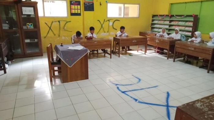 Coretan bertuliskan XTC di ruang kelas SD Banjar