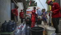 Mobil yang membawa air bersih ini telah ditunggu warga yang membawa galon maupun wadah untuk menerima air bersih.