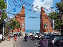Gapura atau pintu masuk utama di Pantai Kuta, Badung, Bali, pada Selasa (19/9/2023). Tampak dua patung mirip tokoh punakawan dalam kisah pewayangan menghiasi sisi kanan dan kiri gapura.
