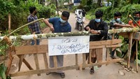 Warga memasang tanda bertuliskan  Zona penahanan Nipah  di barikade, yang dipasang untuk memblokir jalan setelah pihak berwenang menyatakan daerah tersebut sebagai zona penahanan, untuk mencegah penyebaran virus Nipah di desa Ayanchery di distrik Kozhikode, Kerala. Pada Rabu (13/9/2023), sebanyak 706 warga, termasuk 153 di antaranya petugas kesehatan India telah menjalani tes untuk mengetahui kemungkinan penularan virus.