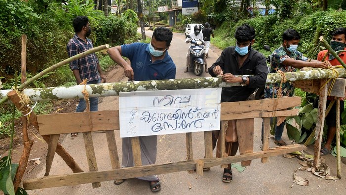 Residents fix a sign reading 