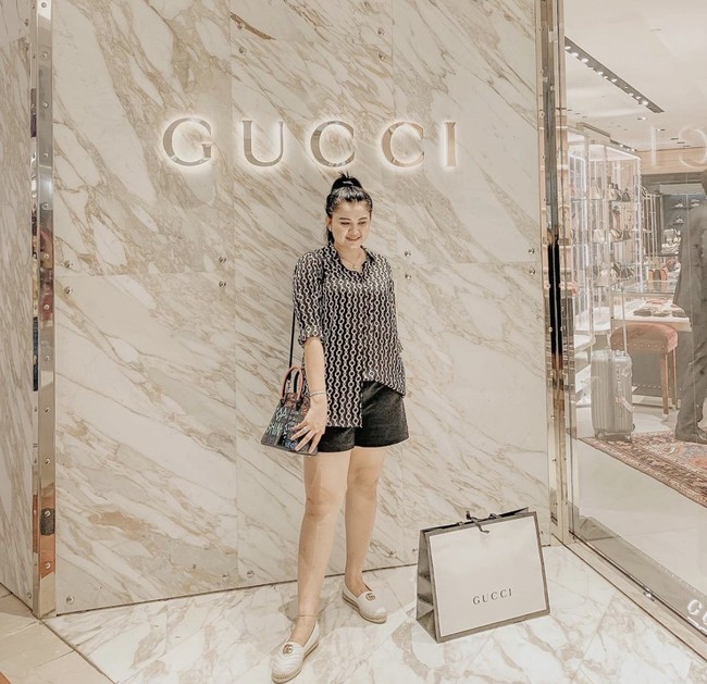Potret Nur Utami di 2019 yang berpose di depan toko Gucci dengan tas belanja brand mewah tersebut. Foto: Dok. Instagram/@nurutami.s