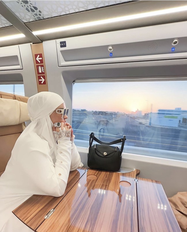 Foto Nur Utami dalam perjalanan umrah. Ia berpose dengan hijab putih dan tas Hermes. Kolom komentar di foto ini disindir oleh netizen. Apa hukumnya ibadah tapi menggunakan uang yang dicuci? sindir netizen: Foto: Dok. Instagram