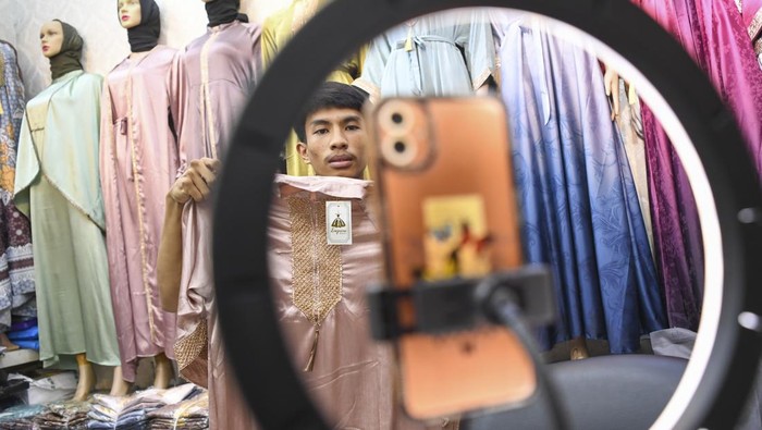 Pedagang menawarkan dagangannya secara daring melalui media sosial di Pasar Tanah Abang, Jakarta, Selasa (19/9/2023). Sejumlah pedagang di pasar tersebut menyatakan mengkombinasikan dengan penjualan daring guna meningkatkan penjualan dan menjangkau pasar yang lebih luas. ANTARA FOTO/M Risyal Hidayat/aww.